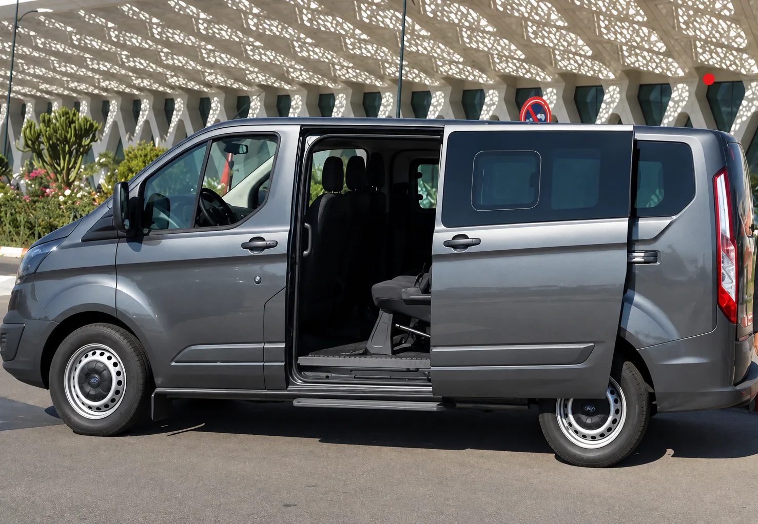 Private transfer minivan with its sliding door open outside an airport in Morocco